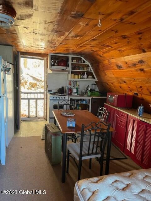 interior space with light carpet, vaulted ceiling, and wood ceiling