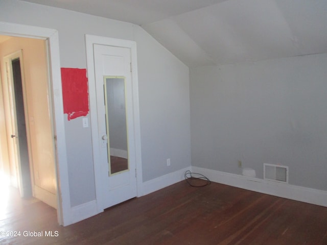 bonus room featuring dark wood-type flooring and vaulted ceiling