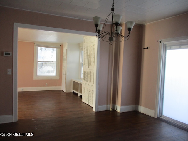 unfurnished dining area with radiator heating unit, dark hardwood / wood-style floors, and a notable chandelier