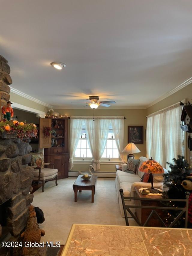 carpeted living room featuring crown molding and ceiling fan