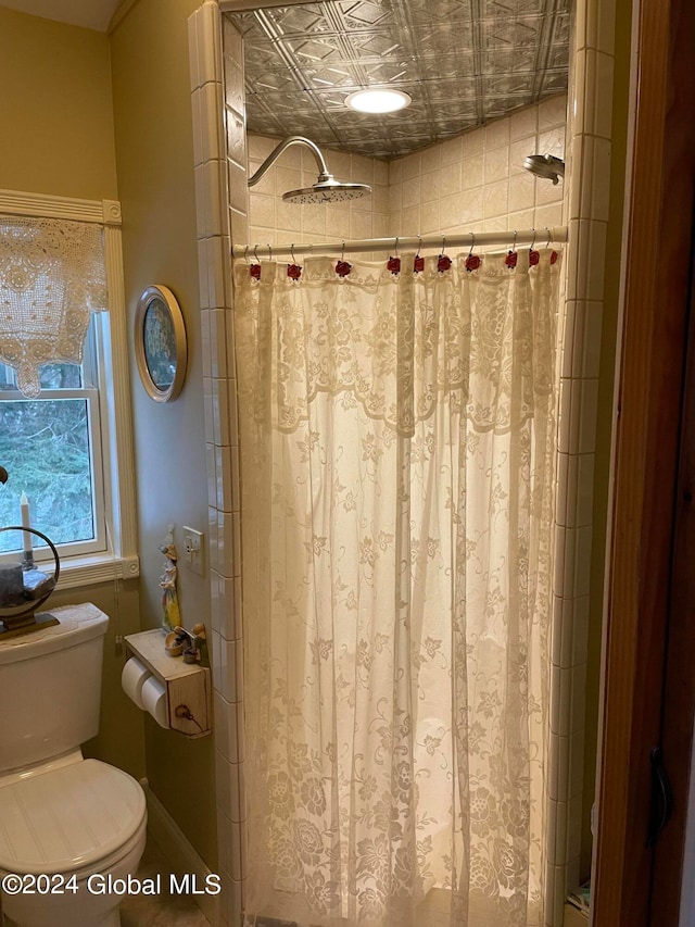 bathroom with curtained shower and toilet