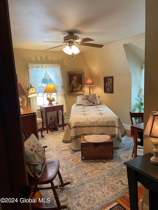 bedroom featuring ceiling fan, hardwood / wood-style flooring, and baseboard heating