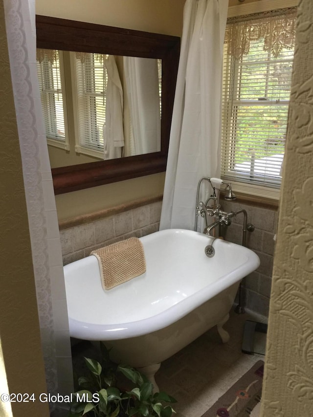 bathroom with tile walls and a bathtub