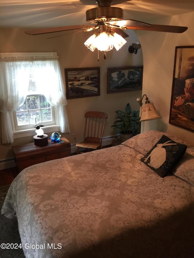 bedroom featuring ceiling fan and a baseboard heating unit