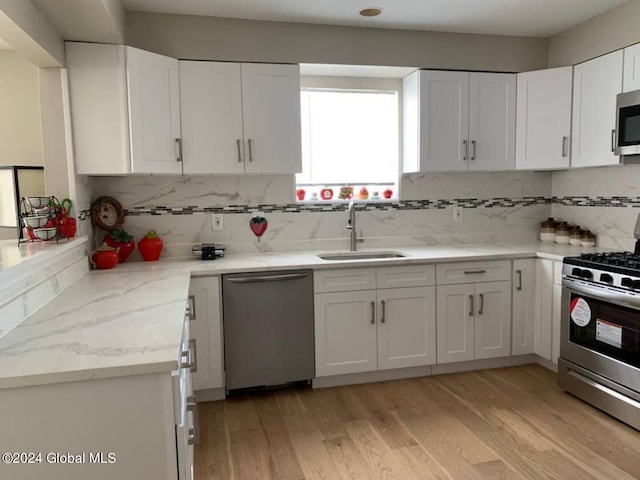 kitchen featuring white cabinets, tasteful backsplash, stainless steel appliances, and sink