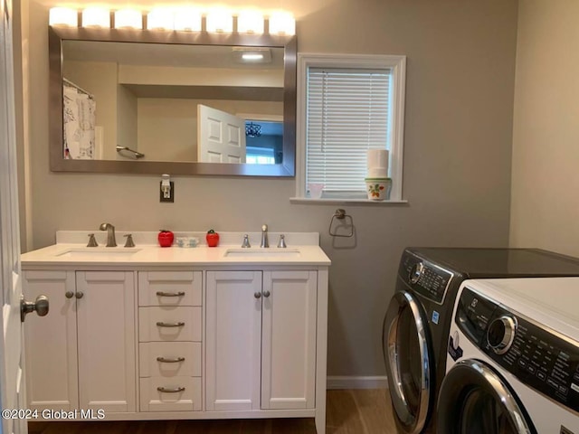 washroom featuring washer and dryer, dark hardwood / wood-style floors, and sink