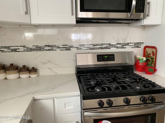 kitchen featuring white cabinets, backsplash, and appliances with stainless steel finishes