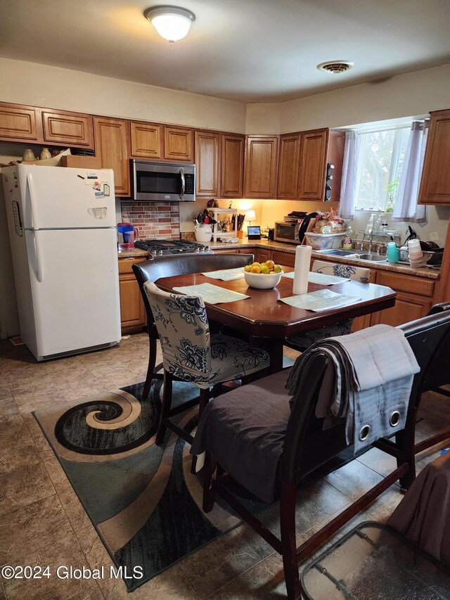 kitchen with light tile floors, appliances with stainless steel finishes, and tasteful backsplash