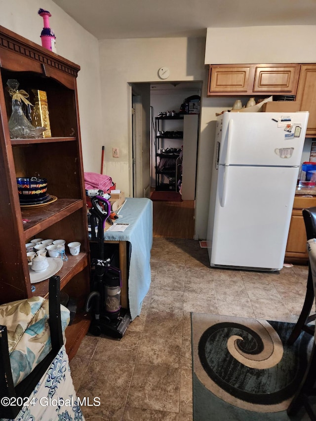 kitchen with light tile flooring and white fridge