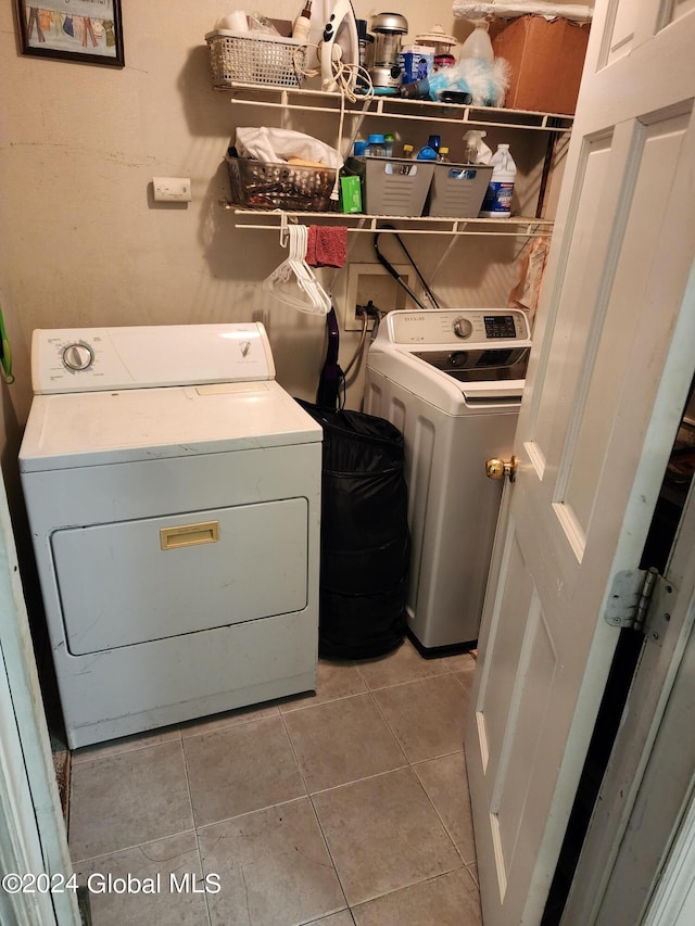 laundry area with separate washer and dryer, light tile flooring, and hookup for a washing machine