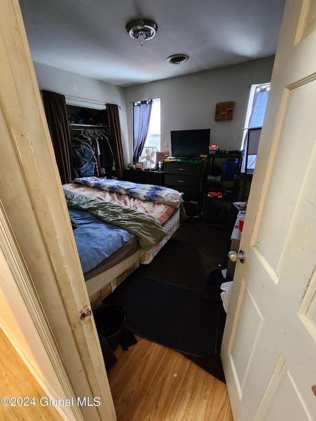 bedroom with light hardwood / wood-style floors and a closet