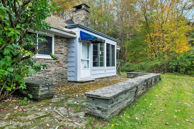 view of side of home with a patio area and a yard