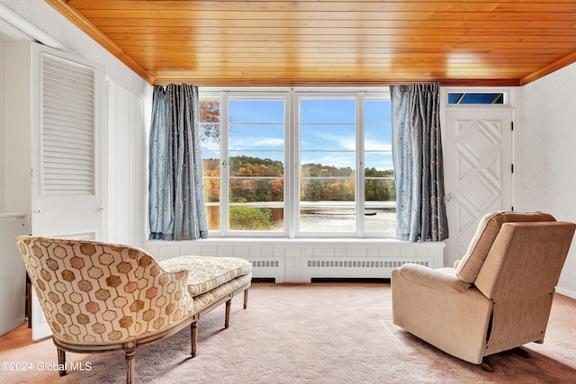 sitting room featuring wooden ceiling, radiator, carpet flooring, and crown molding