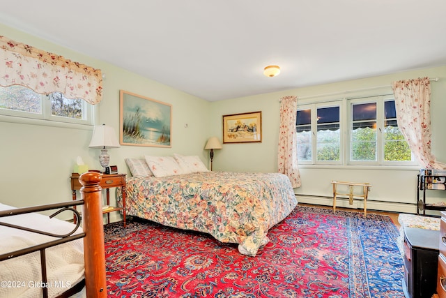 bedroom with baseboard heating and hardwood / wood-style floors