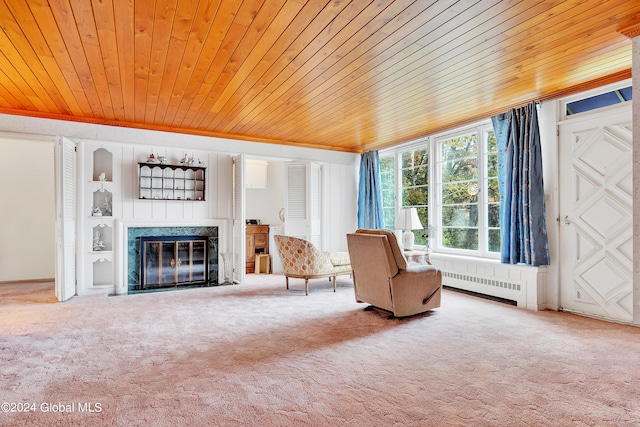 unfurnished room with a fireplace, carpet flooring, built in shelves, wooden ceiling, and radiator