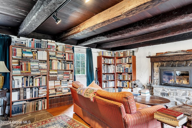 sitting room featuring beamed ceiling, a fireplace, hardwood / wood-style flooring, and wood ceiling