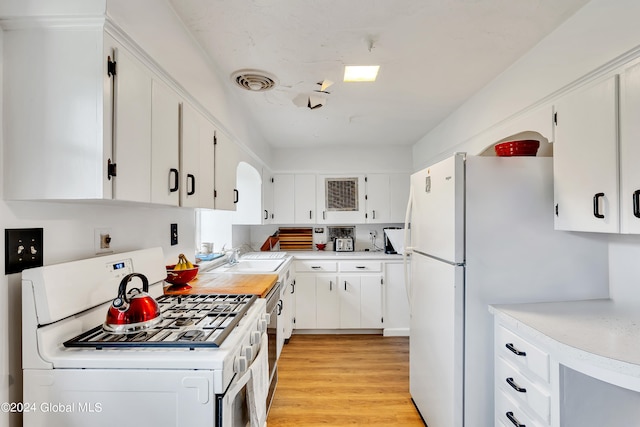 kitchen featuring sink, white appliances, white cabinets, and light hardwood / wood-style floors