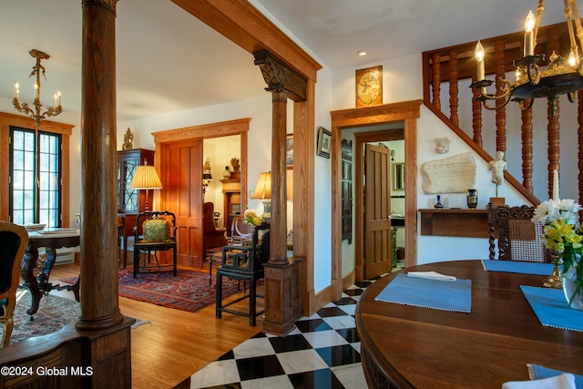 interior space featuring wood-type flooring, ornate columns, and a notable chandelier