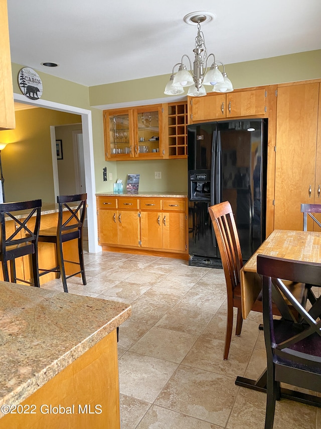 kitchen featuring a chandelier, black fridge with ice dispenser, and decorative light fixtures