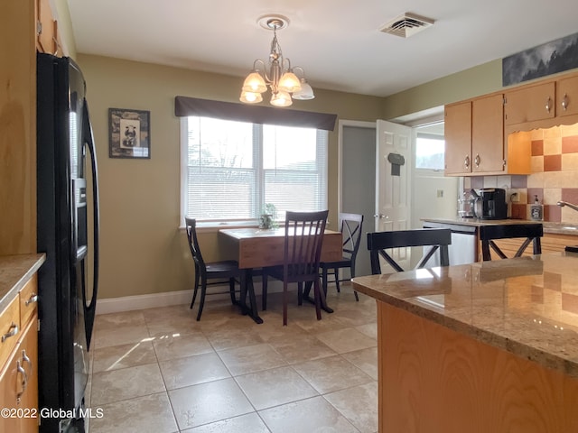 kitchen featuring a chandelier, hanging light fixtures, backsplash, black fridge with ice dispenser, and stainless steel dishwasher