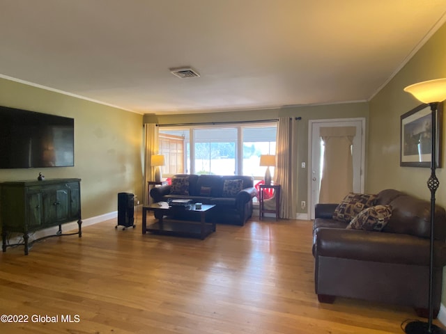 living room with light wood-type flooring and crown molding