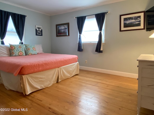 bedroom with crown molding and light hardwood / wood-style flooring