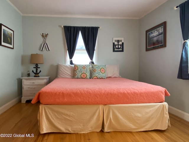 bedroom featuring hardwood / wood-style flooring and ornamental molding