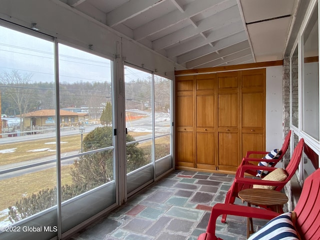 sunroom with a healthy amount of sunlight and lofted ceiling