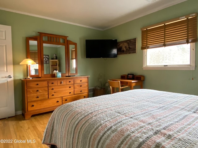 bedroom with light hardwood / wood-style flooring and ornamental molding