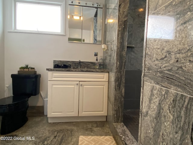 bathroom featuring tiled shower, vanity, and toilet