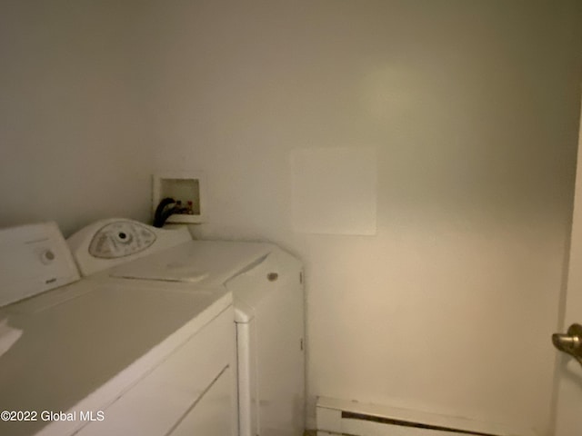 washroom with washing machine and clothes dryer and a baseboard radiator