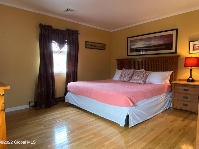 bedroom with crown molding and light hardwood / wood-style flooring