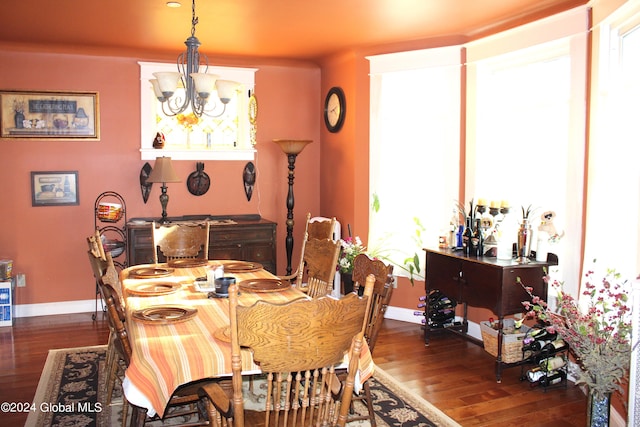dining space with dark hardwood / wood-style floors and a chandelier