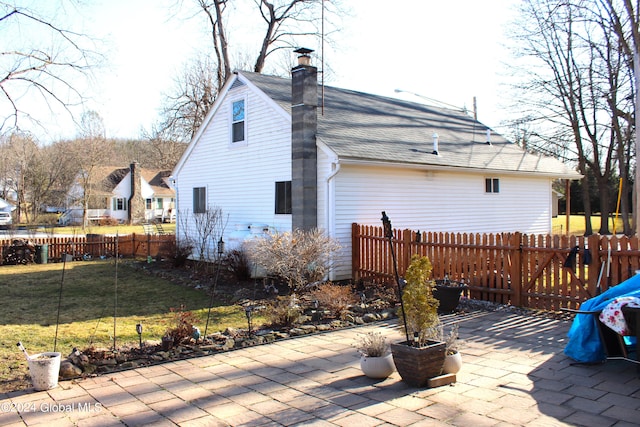 rear view of property featuring a lawn and a patio