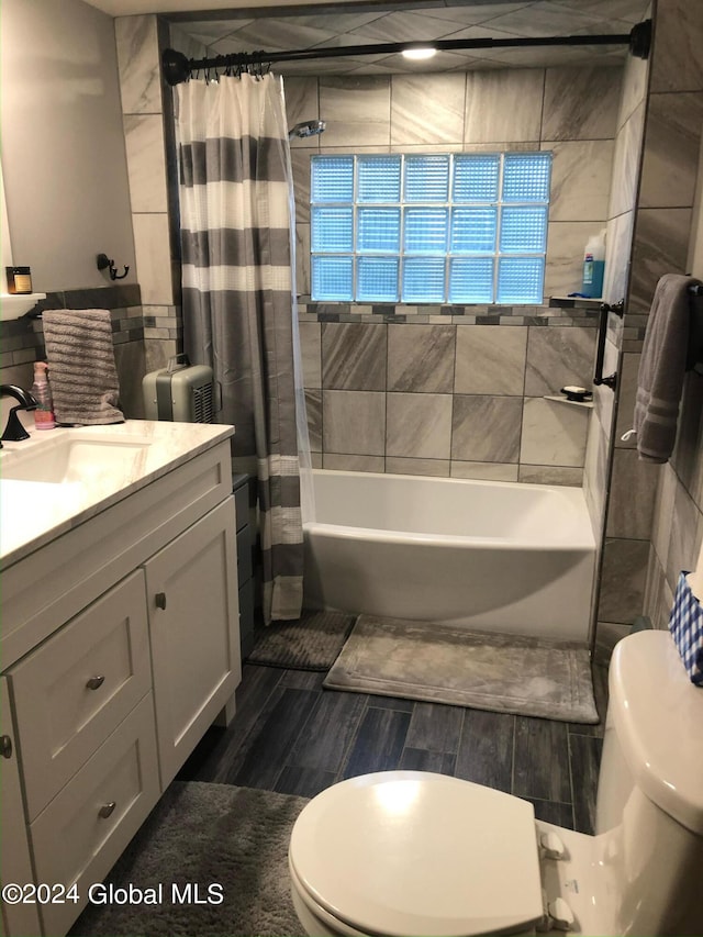 full bathroom featuring vanity, hardwood / wood-style floors, toilet, and shower / bathtub combination with curtain
