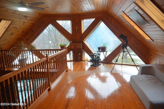 bonus room featuring a wood stove, lofted ceiling, ceiling fan, light hardwood / wood-style floors, and wooden ceiling