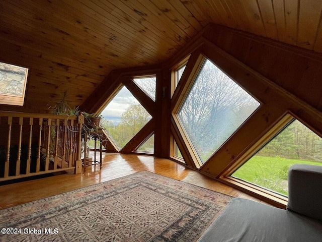 interior space featuring wood ceiling, vaulted ceiling with skylight, and light hardwood / wood-style floors