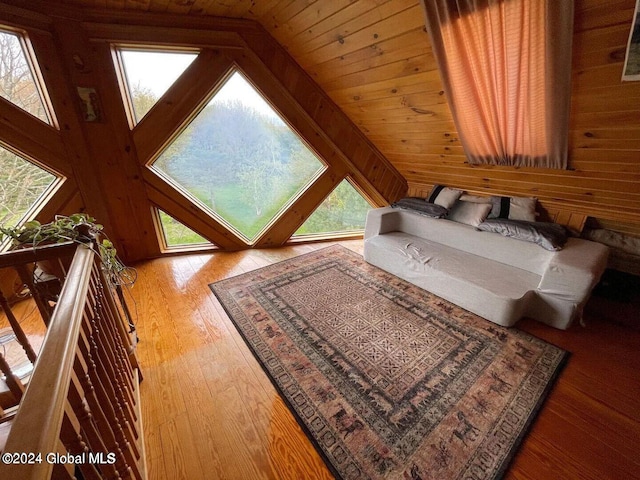 bedroom featuring wood walls, wooden ceiling, vaulted ceiling, and light hardwood / wood-style flooring