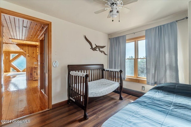 bedroom featuring dark hardwood / wood-style flooring, multiple windows, and ceiling fan