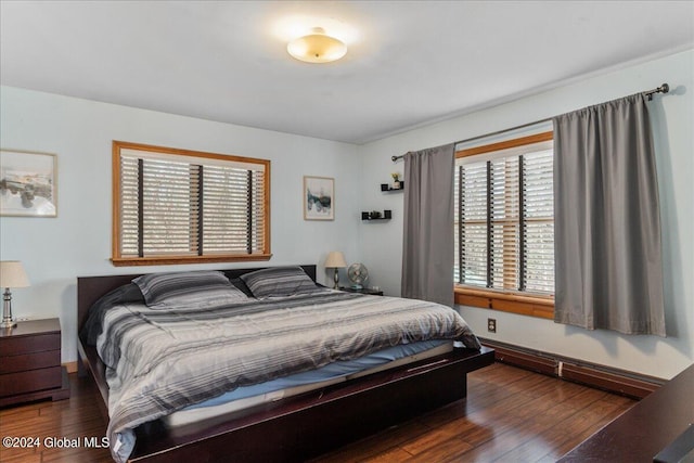 bedroom featuring baseboard heating and dark hardwood / wood-style floors