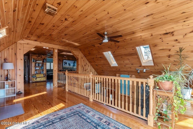 additional living space with lofted ceiling with skylight, wood ceiling, ceiling fan, and light hardwood / wood-style flooring