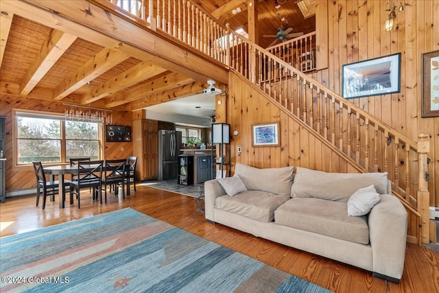 living room featuring dark hardwood / wood-style flooring, ceiling fan, and wood walls