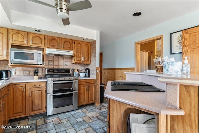 kitchen featuring ceiling fan, stainless steel appliances, backsplash, and dark tile flooring