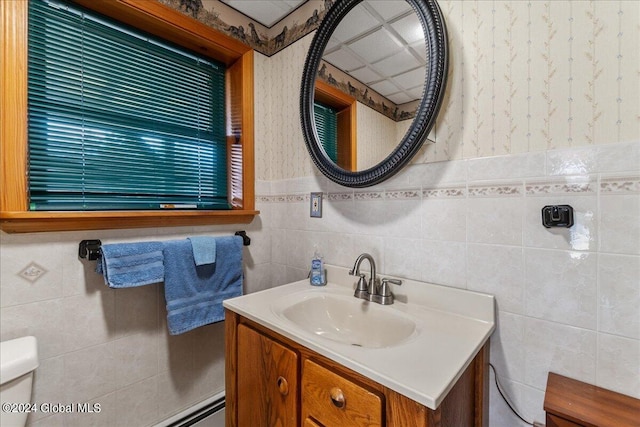 bathroom featuring tile walls, toilet, a drop ceiling, and vanity