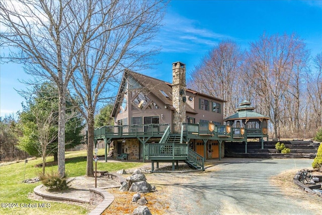 exterior space with a deck, a gazebo, and a lawn