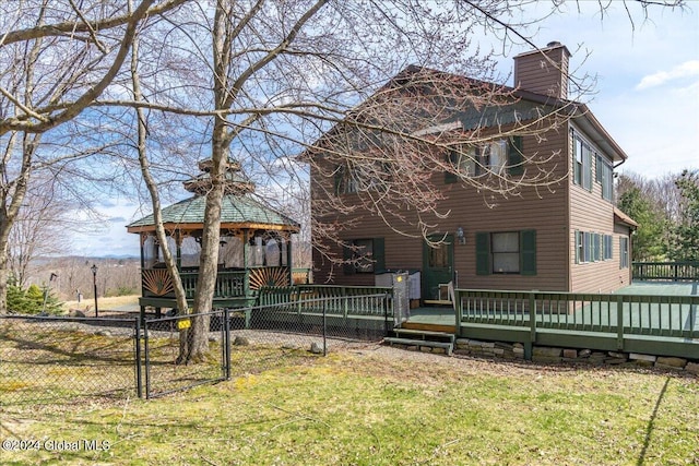 back of property with a yard, a gazebo, and a wooden deck