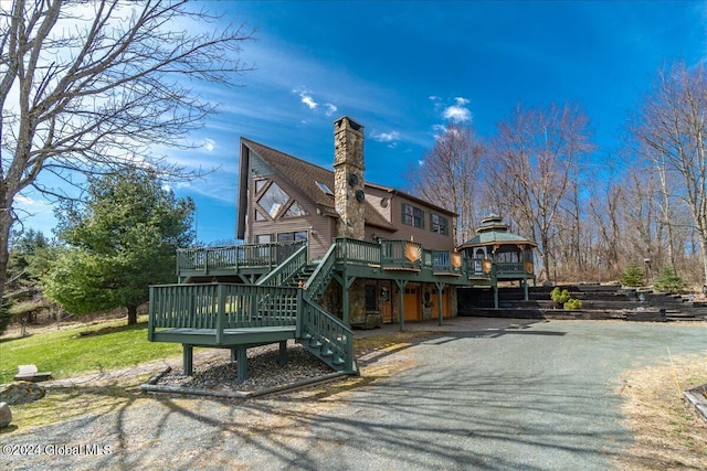 rear view of property featuring a wooden deck