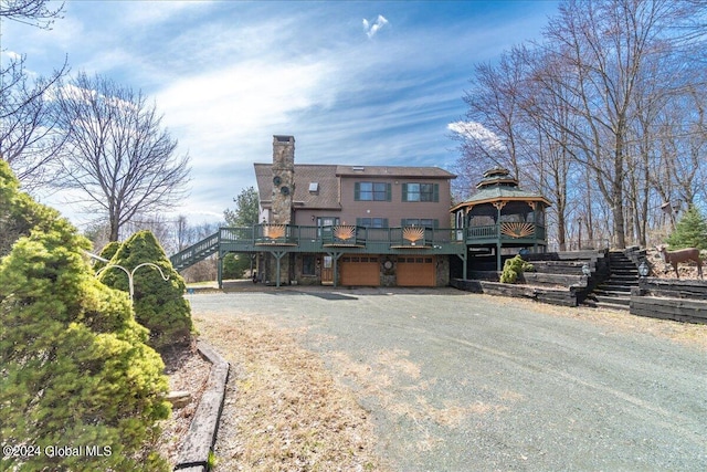 rear view of house featuring a gazebo and a garage