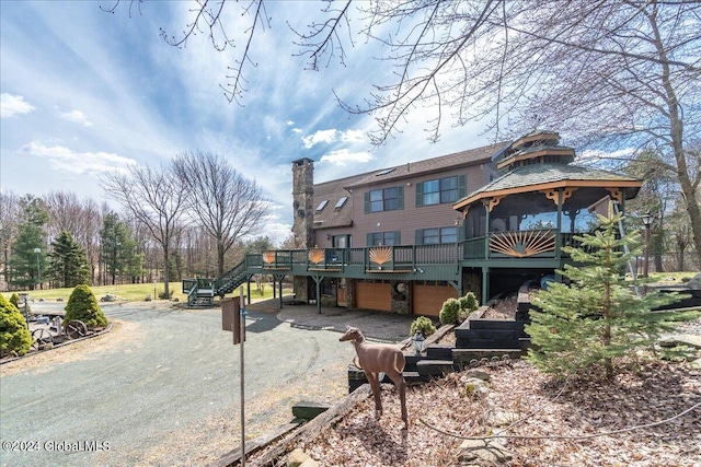 back of property featuring a wooden deck and a patio area