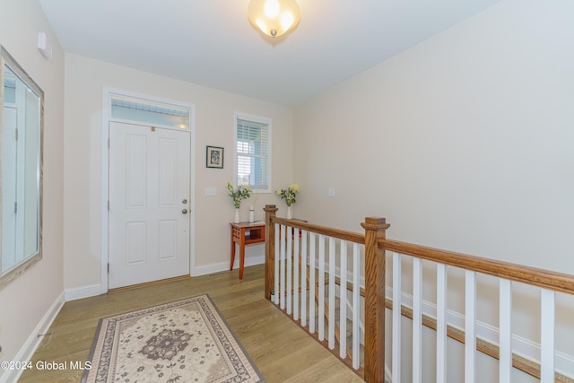 entryway with baseboards and light wood finished floors